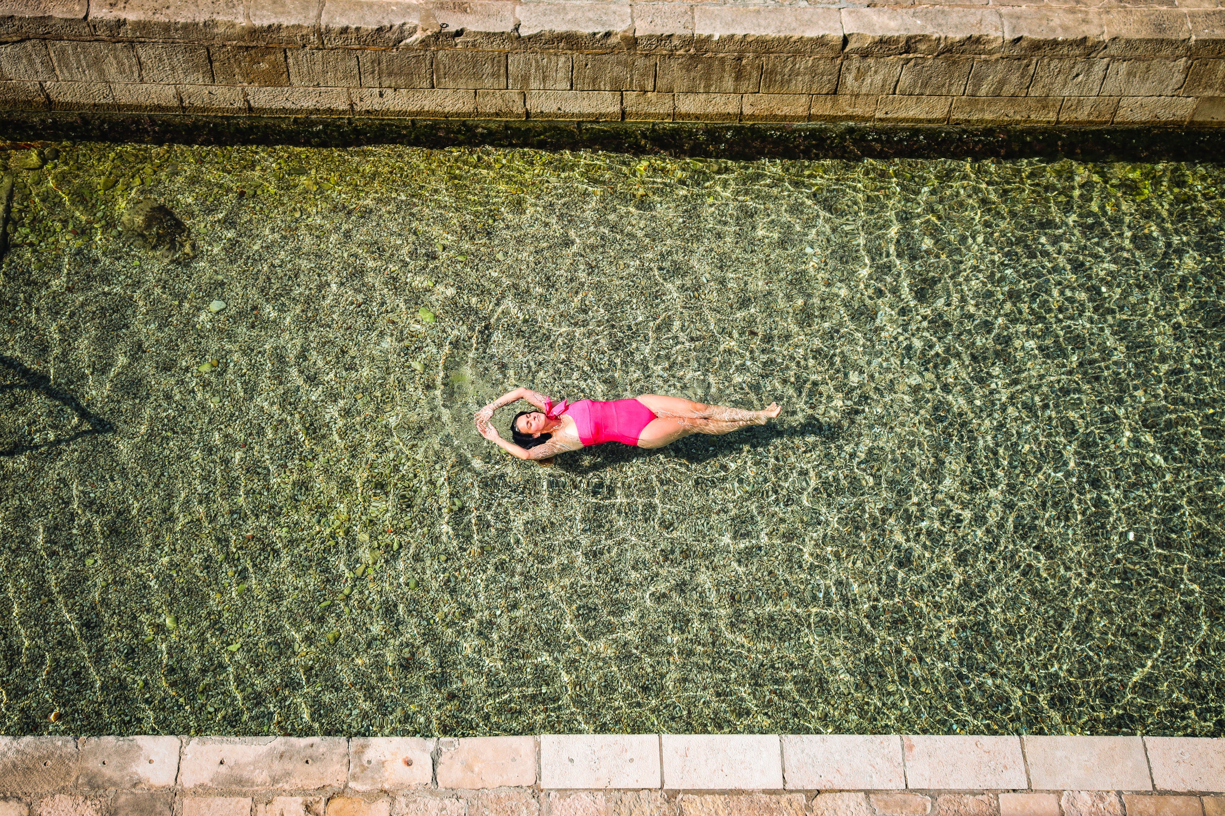 Hot pink one piece swimsuit with one shoulder and tie up in a textured fabric and sewn in moulded cups. 