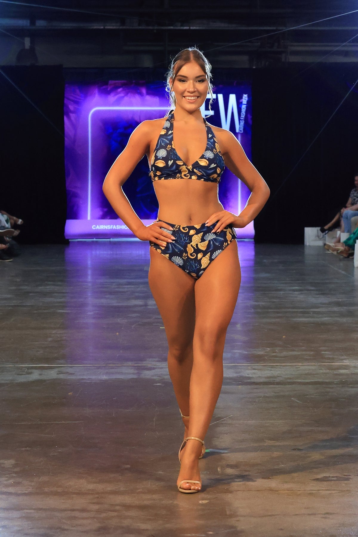 Model poses hands on hips on the runway in the Čiovo navy seashell print bikini set