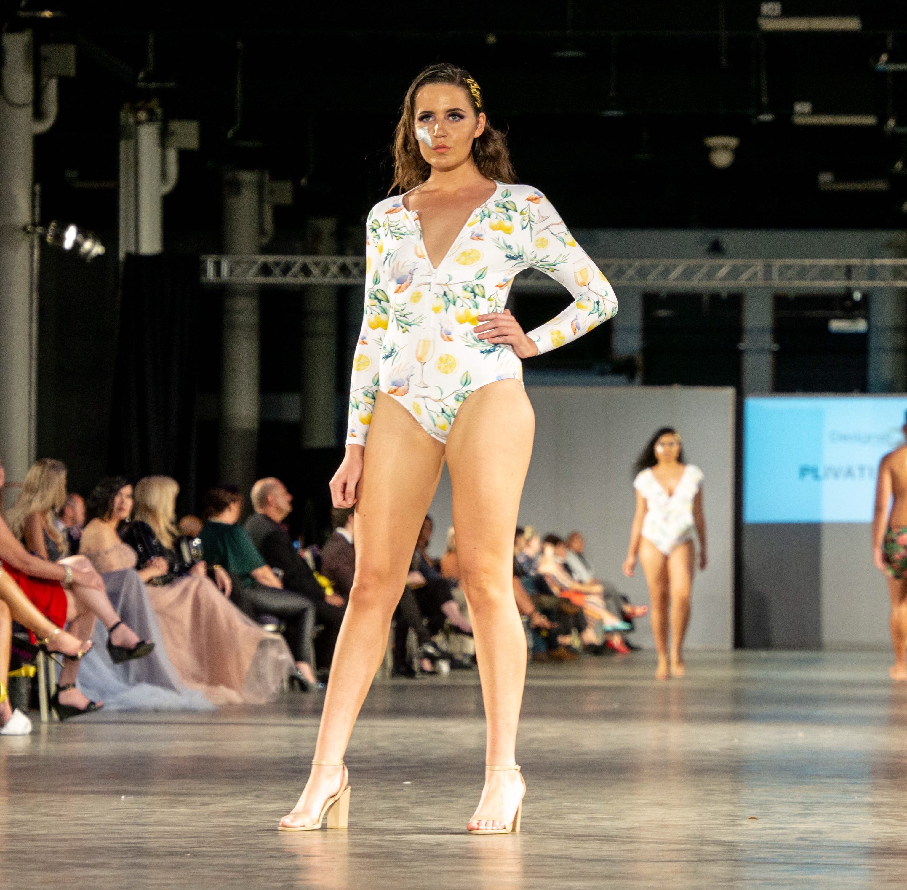 One piece long sleeve swimsuit with open back, front zip and neck tie in the Plivati Adriatic print.